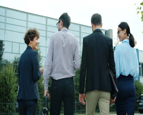 A group of corporate colleagues walking outside an office building in Timisoara during a short afternoon break